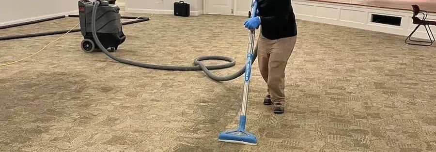 Air movers drying a concrete subfloor behind containment in a North Dallas home