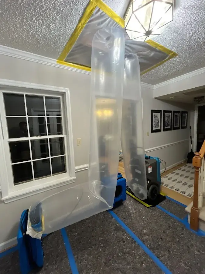 Containment and an air scrubber under a water damaged ceiling after a roof leak
