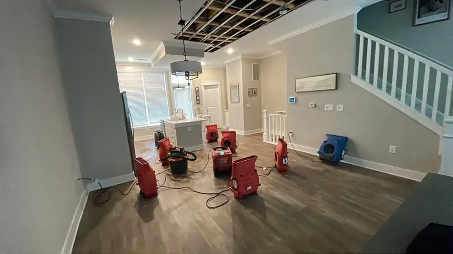 Air movers and dehumidifiers drying a water damaged Addison room