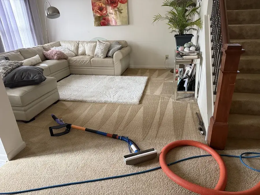 Technician extracting standing water from soaked carpet in an Addison home